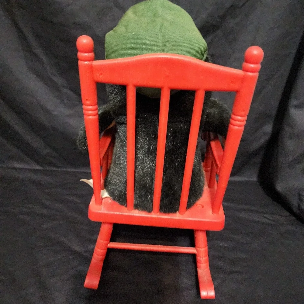 1997 vintage Coca-Cola penguin plush toy sitting in a‎ red rocking chair.